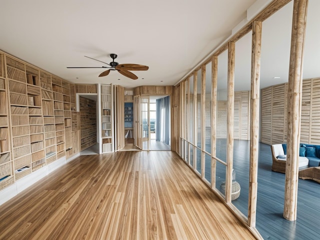 unfurnished living room featuring ceiling fan and hardwood / wood-style flooring