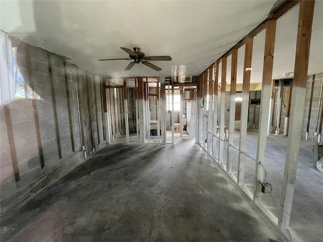 misc room featuring ceiling fan and concrete flooring