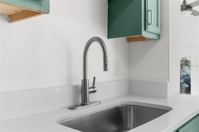 interior details with green cabinets, ceiling fan, and sink