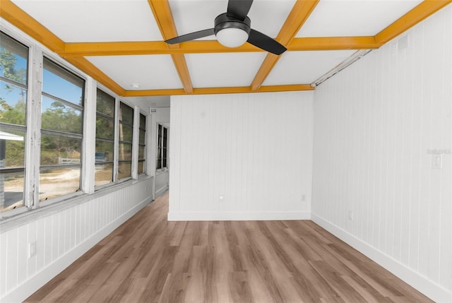 empty room featuring ceiling fan, beamed ceiling, coffered ceiling, and light wood-type flooring