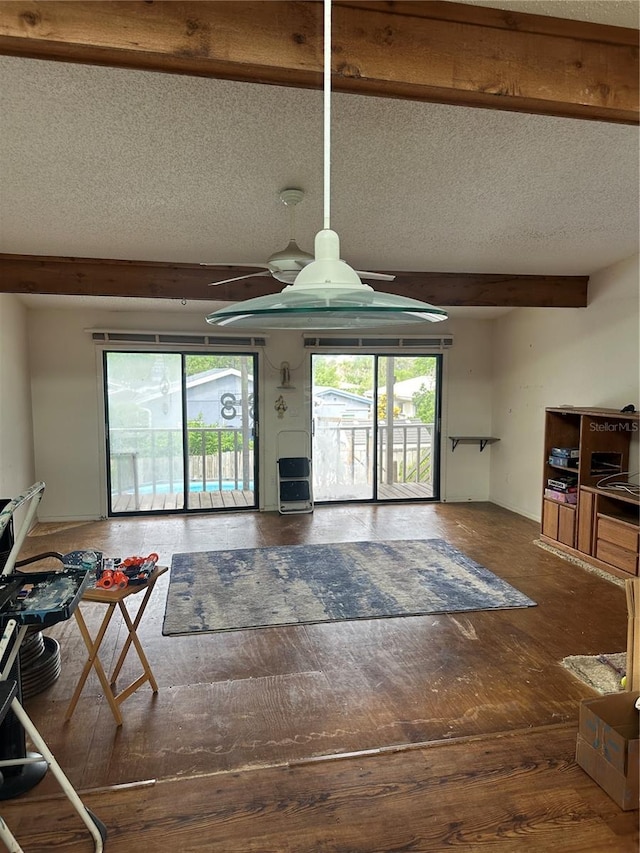 living room with ceiling fan, beam ceiling, and a textured ceiling