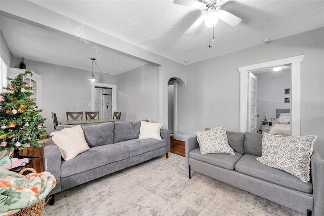 living room with hardwood / wood-style flooring, ceiling fan, and a textured ceiling