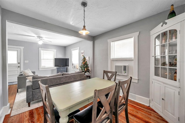 dining area with ceiling fan, a textured ceiling, a wealth of natural light, and light hardwood / wood-style flooring