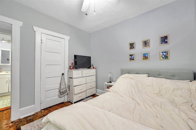 bedroom with ceiling fan, wood-type flooring, and a textured ceiling