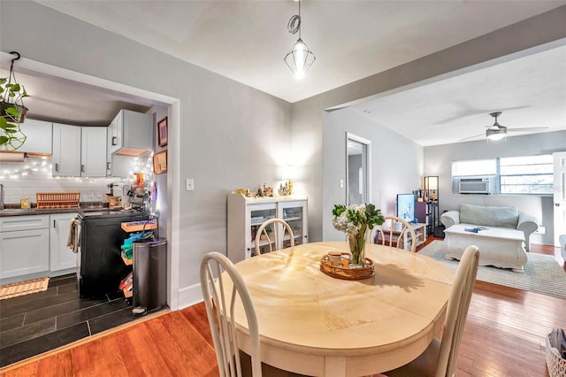 dining area featuring ceiling fan, cooling unit, and dark wood-type flooring