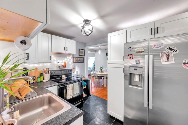 kitchen with white cabinets, tasteful backsplash, sink, black electric range, and stainless steel fridge with ice dispenser