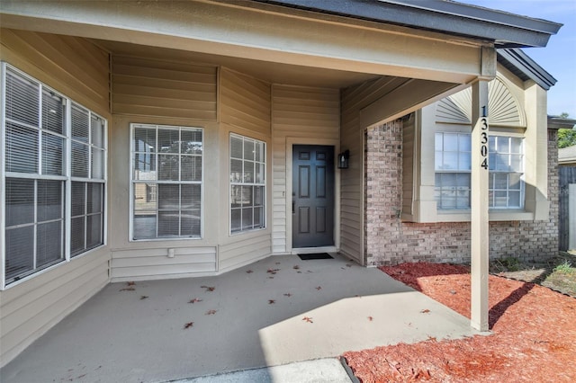 view of exterior entry with a patio