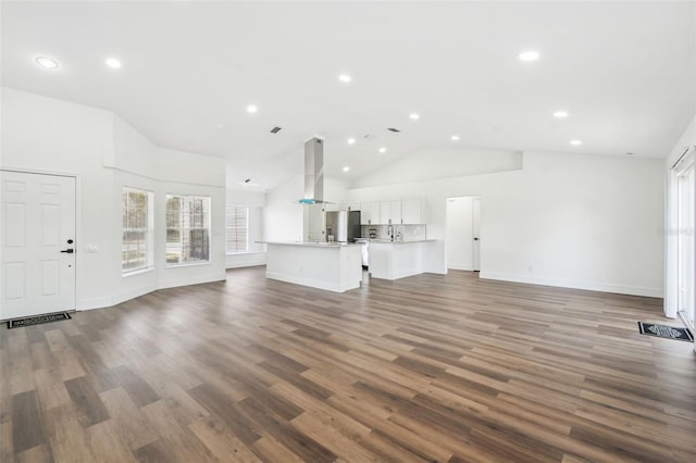 unfurnished living room with dark wood-type flooring and high vaulted ceiling