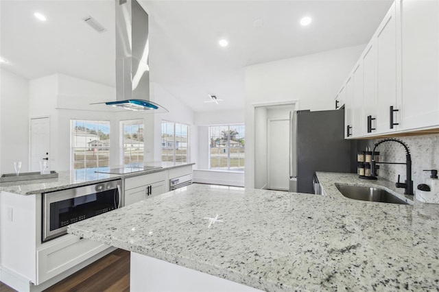 kitchen featuring island range hood, sink, white cabinets, stainless steel appliances, and light stone countertops