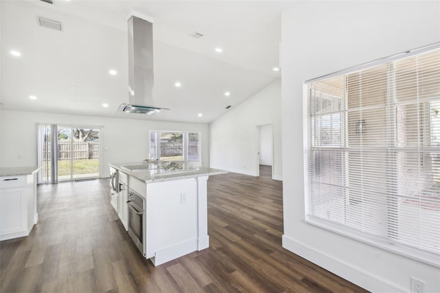 kitchen featuring white cabinets, island exhaust hood, a center island, stainless steel oven, and light stone countertops