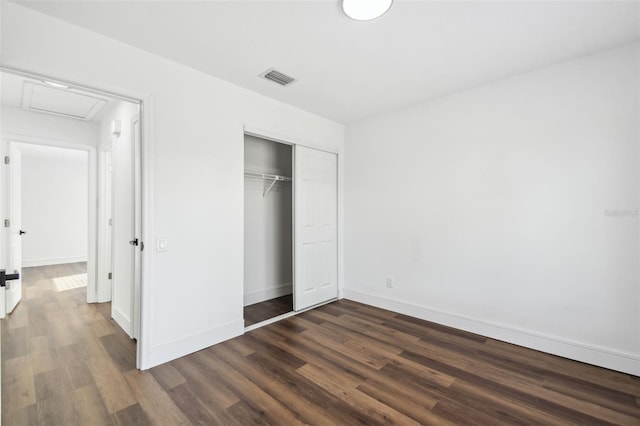 unfurnished bedroom with dark hardwood / wood-style floors and a closet