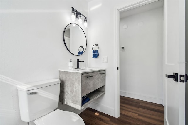 bathroom featuring vanity, wood-type flooring, and toilet