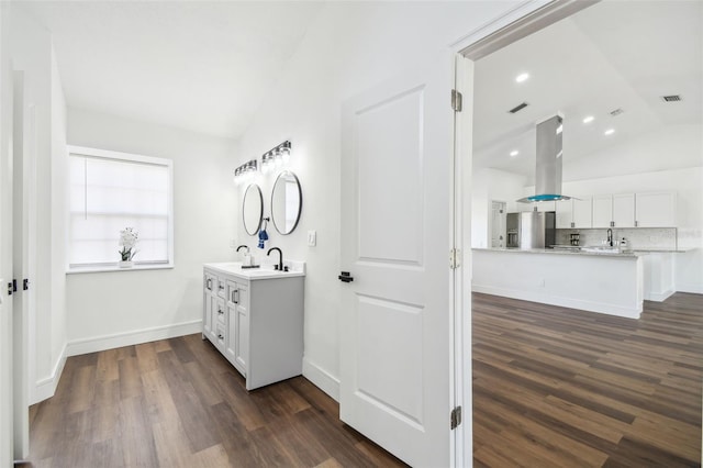 bathroom with lofted ceiling, wood-type flooring, and backsplash