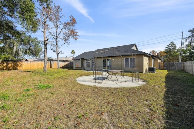 rear view of house with a yard, cooling unit, and a patio area