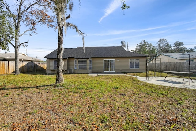 rear view of property with a yard and a patio