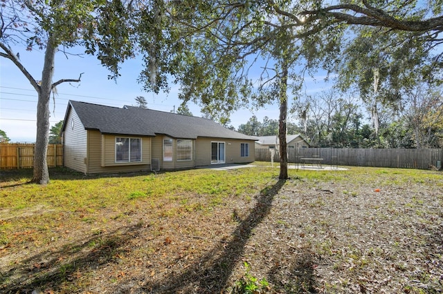 rear view of property featuring a patio and a lawn