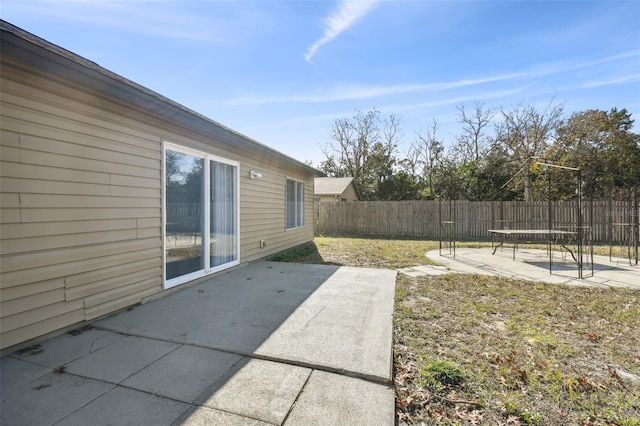 view of yard with a trampoline and a patio