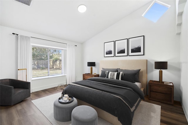 bedroom featuring dark wood-type flooring and vaulted ceiling with skylight