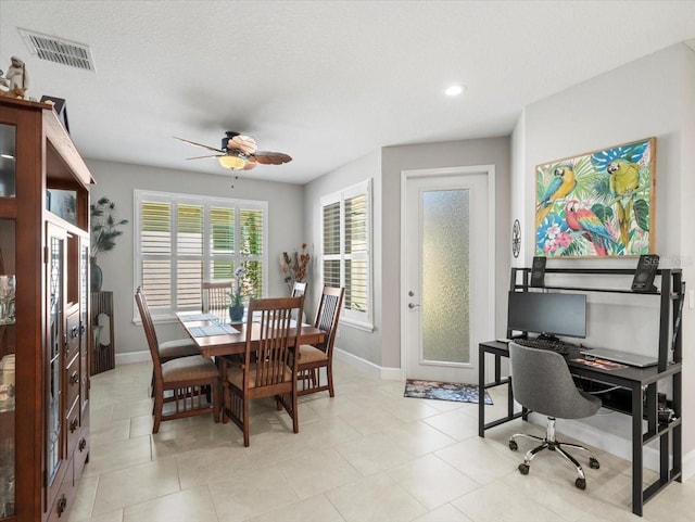 dining area with ceiling fan and a textured ceiling