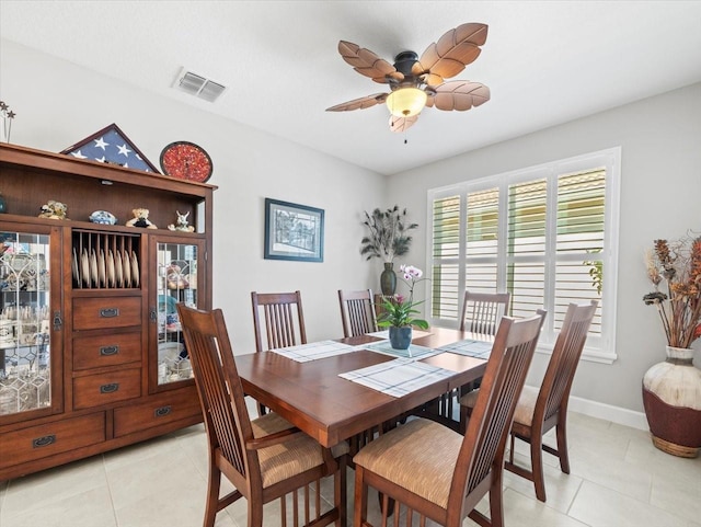 dining space with ceiling fan and light tile patterned flooring