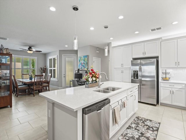 kitchen featuring ceiling fan, white cabinetry, an island with sink, and appliances with stainless steel finishes