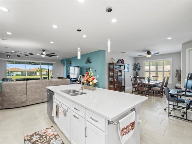 kitchen with ceiling fan, sink, an island with sink, decorative light fixtures, and white cabinets