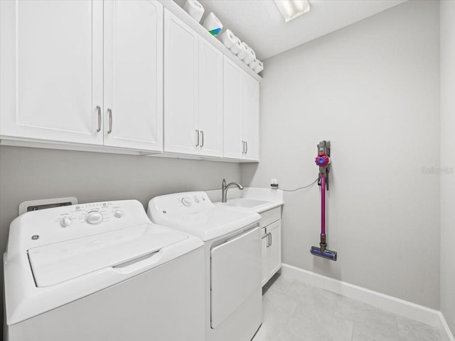 laundry area featuring cabinets, sink, and washing machine and clothes dryer