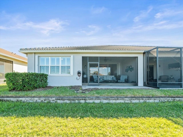 back of property with a yard and a lanai