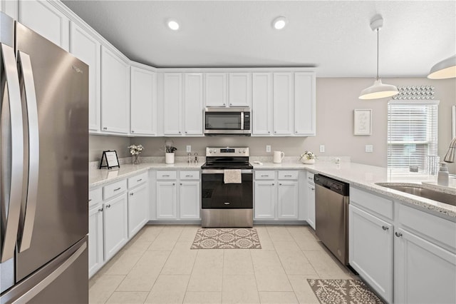 kitchen with sink, decorative light fixtures, white cabinets, and appliances with stainless steel finishes