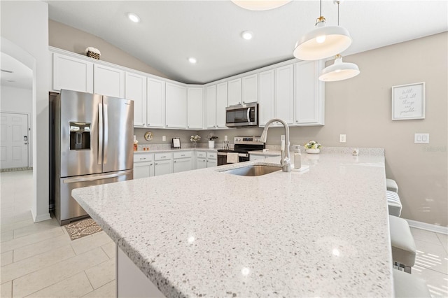 kitchen featuring appliances with stainless steel finishes, pendant lighting, white cabinets, and kitchen peninsula