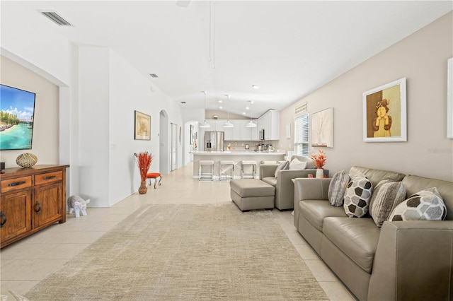 living room with vaulted ceiling and light tile patterned flooring