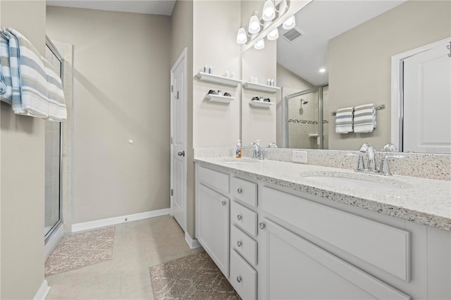 bathroom with an enclosed shower, vanity, and tile patterned floors