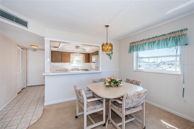 tiled dining area featuring ceiling fan and a textured ceiling