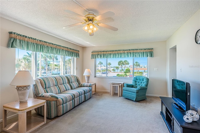 living room featuring a wealth of natural light, ceiling fan, carpet, and a textured ceiling