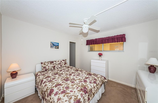 carpeted bedroom featuring ceiling fan and a textured ceiling