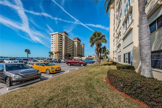 view of parking / parking lot featuring a lawn