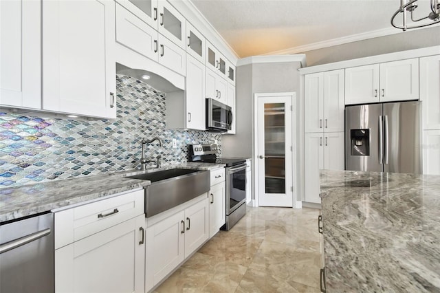 kitchen featuring sink, decorative backsplash, light stone countertops, white cabinetry, and stainless steel appliances