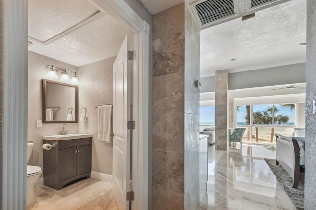 bathroom with vanity, a textured ceiling, and toilet