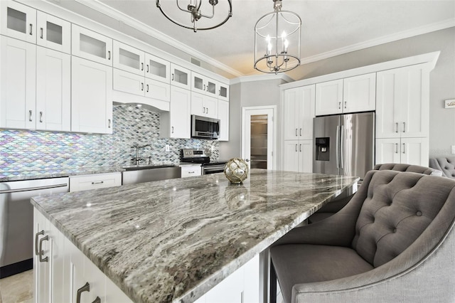 kitchen with white cabinets, pendant lighting, stainless steel appliances, and sink