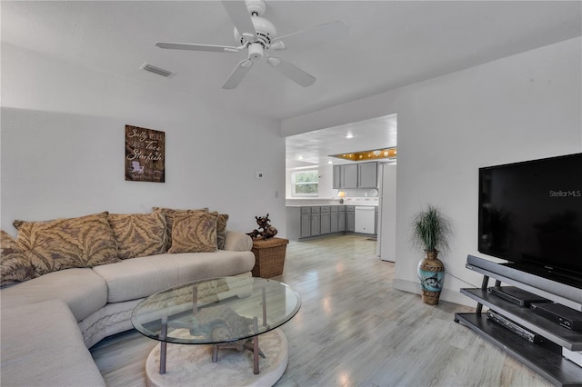 living room featuring light hardwood / wood-style floors and ceiling fan
