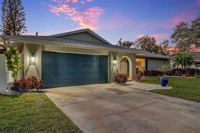 ranch-style home with a garage and a lawn