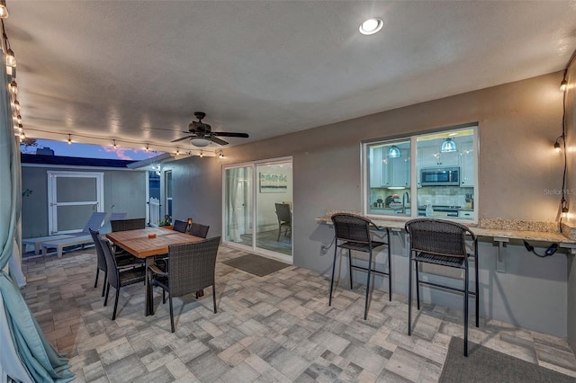 dining space with ceiling fan, track lighting, and sink