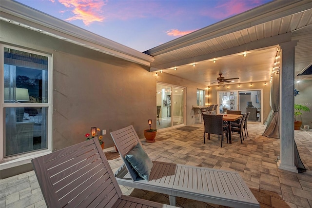 patio terrace at dusk featuring ceiling fan