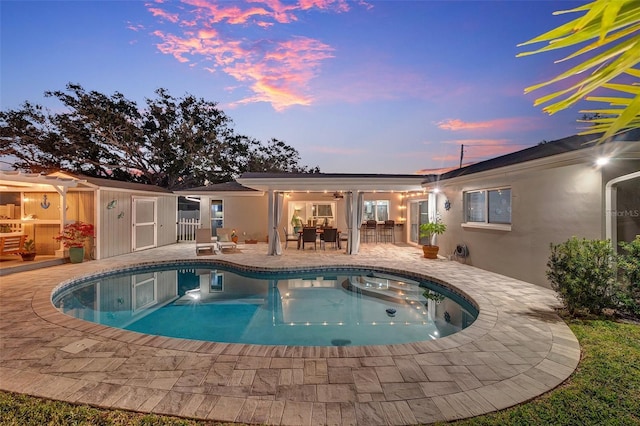 back house at dusk with a patio area and ceiling fan