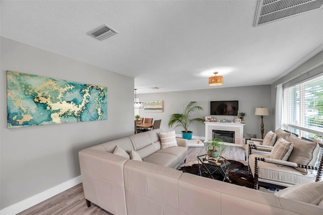 living room featuring a textured ceiling and light hardwood / wood-style flooring