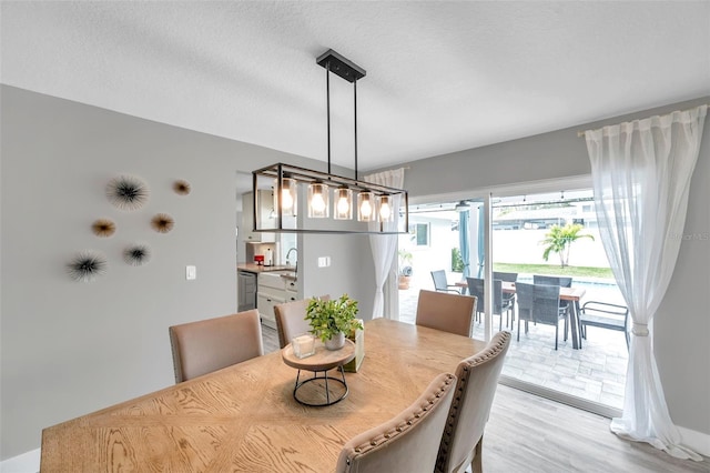 dining room featuring a textured ceiling and light wood-type flooring