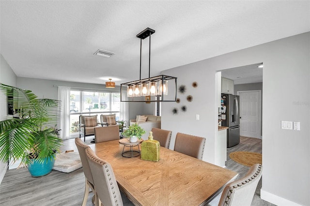 dining room with an inviting chandelier and light wood-type flooring