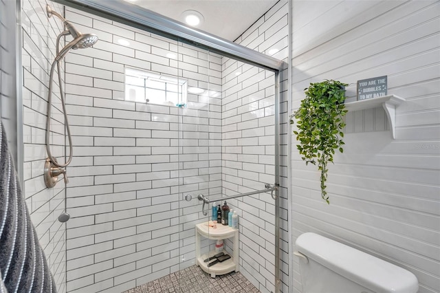 bathroom with toilet, tile patterned floors, and walk in shower