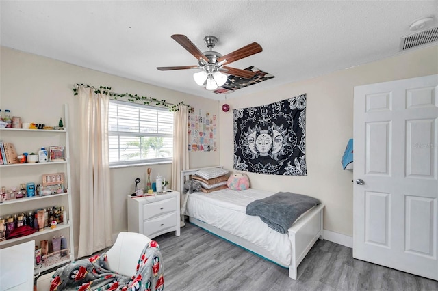 bedroom featuring ceiling fan, a textured ceiling, and hardwood / wood-style flooring