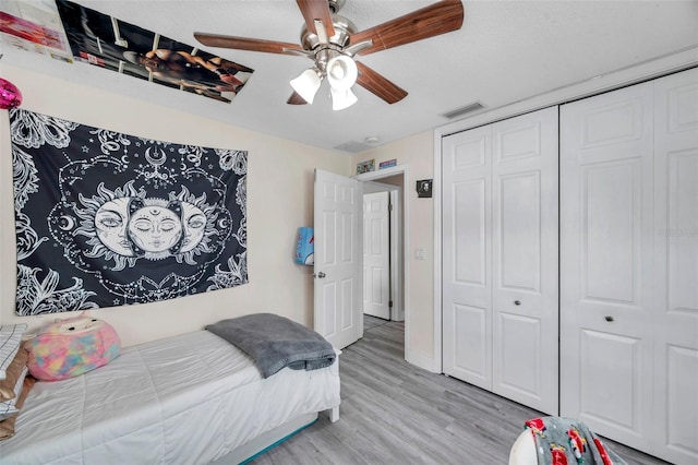 bedroom with ceiling fan, a closet, and light wood-type flooring